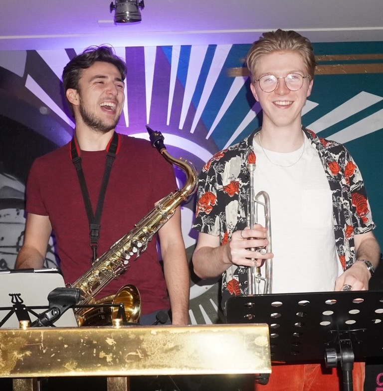 Laughing with a tenor saxophone at a Hot Content gig