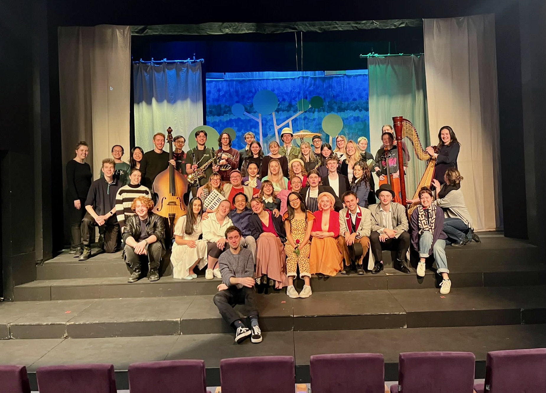 Jonathan Parapadakis holding a piccolo, flute, clarinet, alto saxophone and cor anglais / english horn. Not pictured, Jonathan Parapadakis also played oboe, soprano saxophone, melodica, recorder. This is a group photo